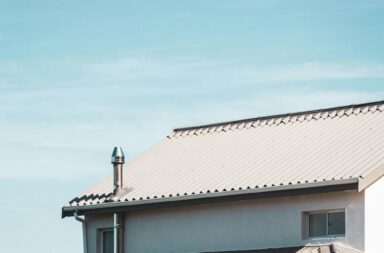 A contemporary house rooftop under a clear blue sky, showcasing architectural design.